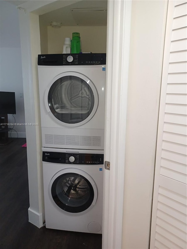 clothes washing area featuring stacked washer / dryer