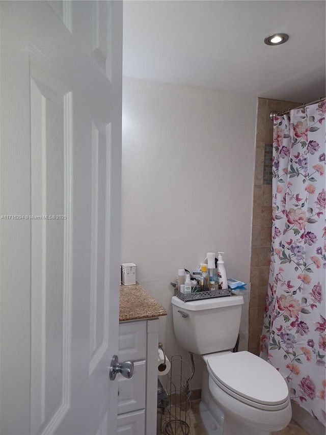 bathroom with curtained shower, toilet, and vanity