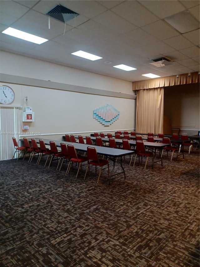 dining room featuring a drop ceiling and carpet floors