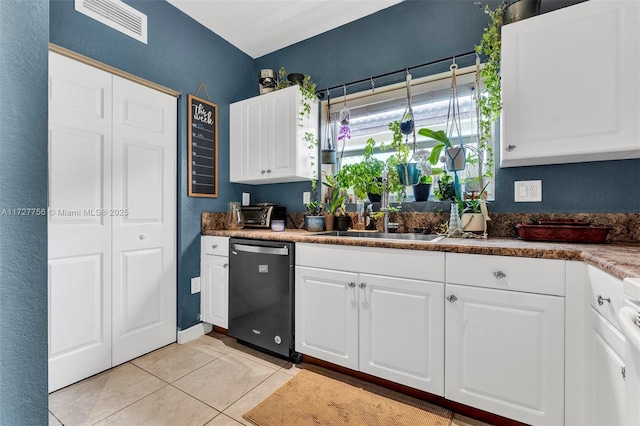 kitchen featuring light tile patterned floors, dishwashing machine, a sink, visible vents, and white cabinets