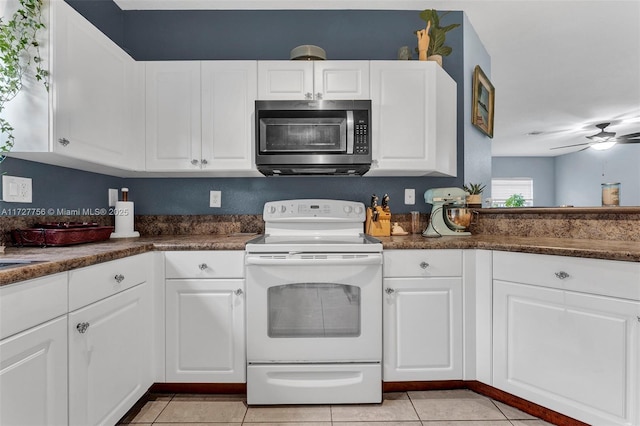kitchen with white cabinets, a ceiling fan, electric stove, stainless steel microwave, and light tile patterned flooring