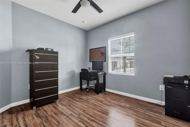 office space with dark wood-style flooring, a ceiling fan, and baseboards
