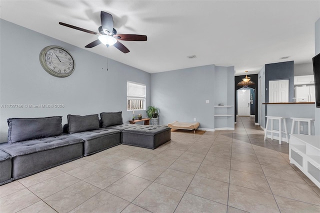 living room featuring light tile patterned floors, ceiling fan, visible vents, and baseboards