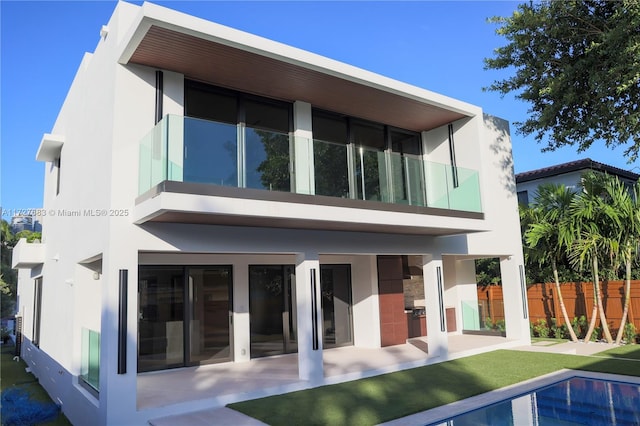 rear view of house with a fenced in pool and a yard