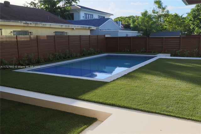 view of pool with a lawn