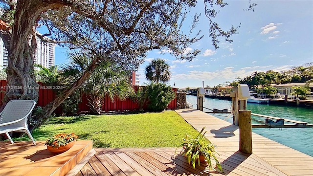 view of dock featuring a lawn and a water view