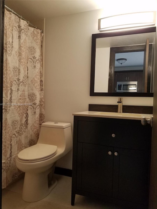 bathroom featuring vanity, tile patterned floors, and toilet