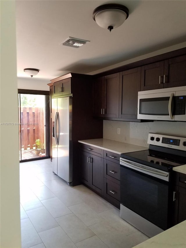 kitchen with tasteful backsplash, dark brown cabinets, and stainless steel appliances