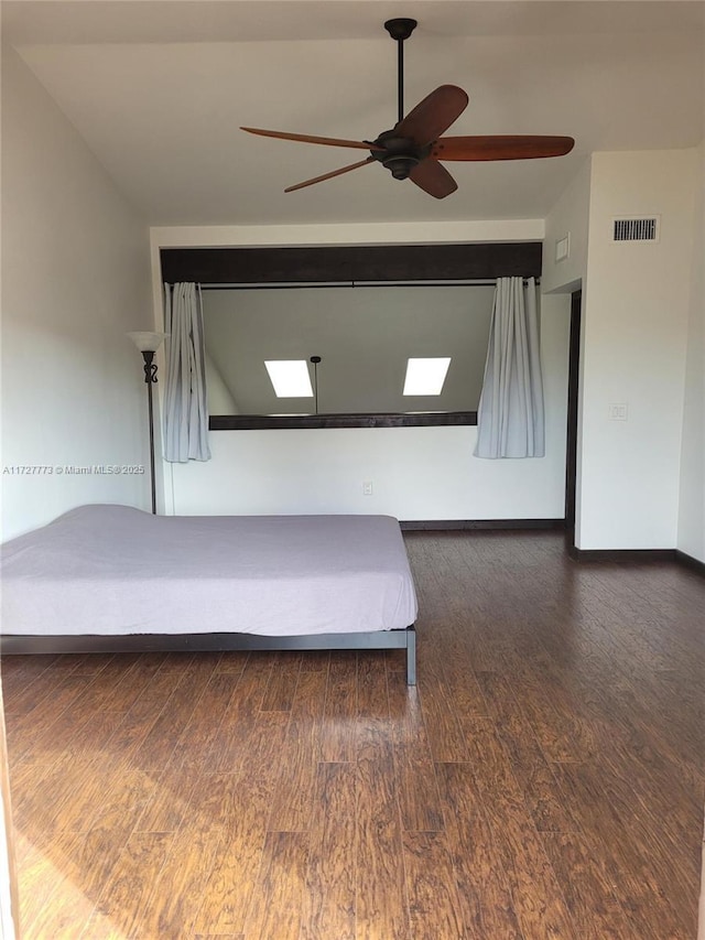 unfurnished bedroom featuring ceiling fan, dark hardwood / wood-style flooring, and vaulted ceiling