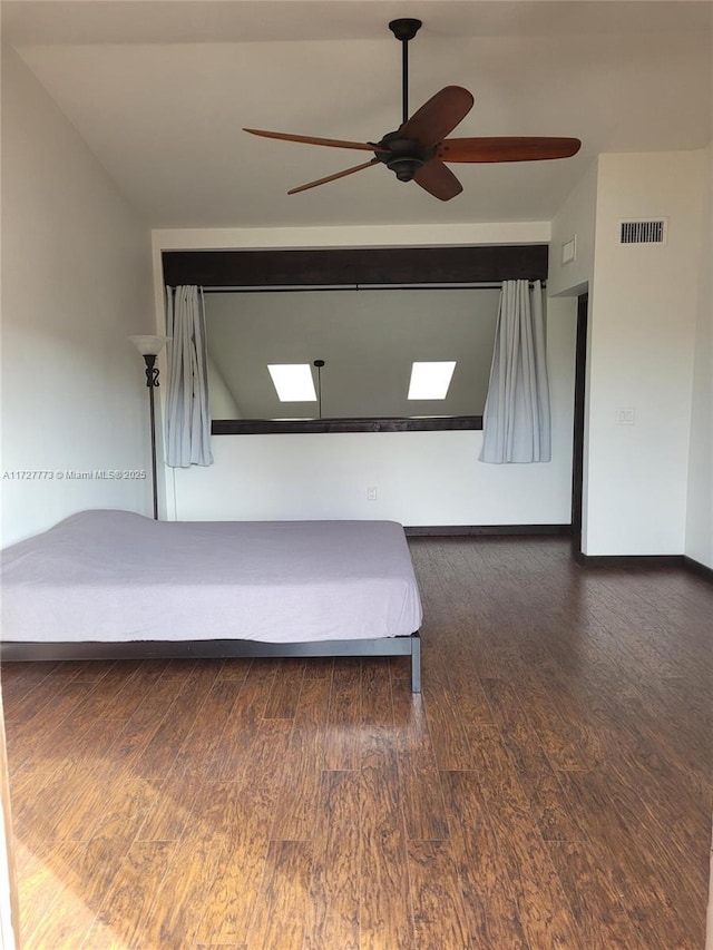 bedroom with ceiling fan, wood finished floors, and visible vents