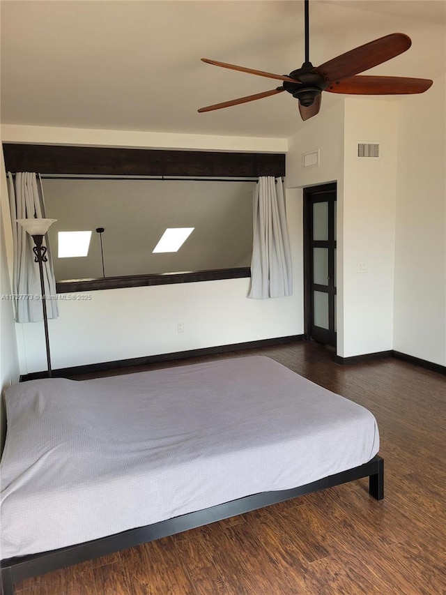 bedroom with baseboards, wood finished floors, visible vents, and ceiling fan