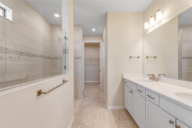 bathroom with tiled shower and vanity