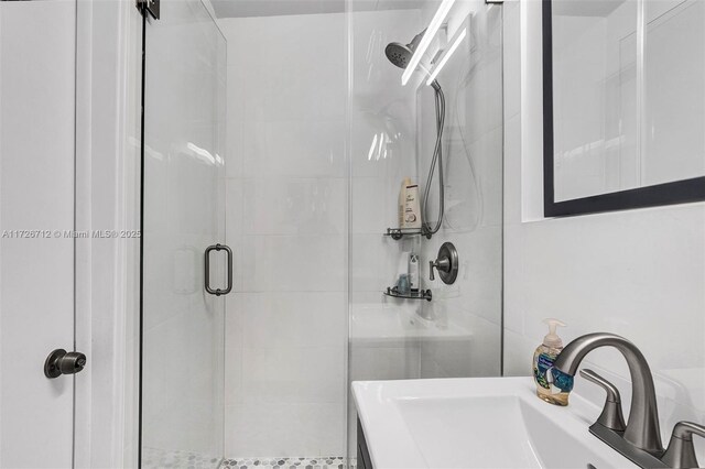 bathroom featuring walk in shower, vanity, and tile walls