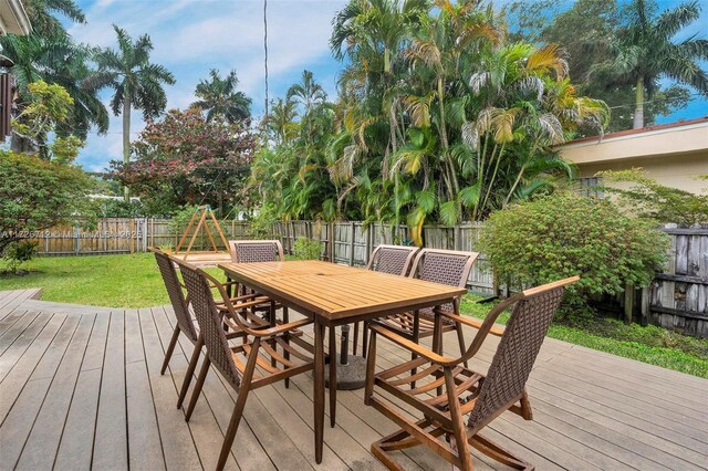 wooden terrace featuring a lawn