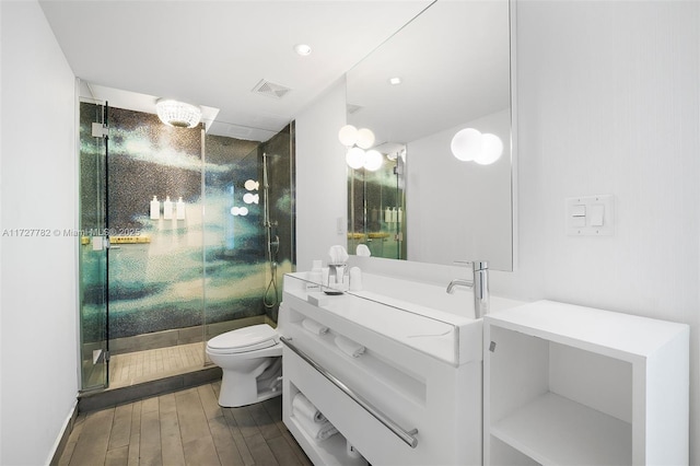 bathroom featuring toilet, vanity, and an enclosed shower