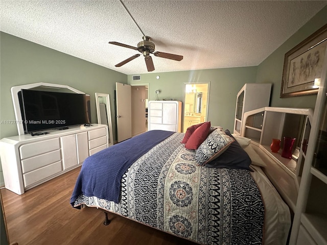 bedroom with hardwood / wood-style flooring, a textured ceiling, ensuite bath, and ceiling fan