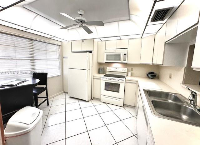 kitchen featuring sink, ceiling fan, white appliances, and light tile patterned flooring