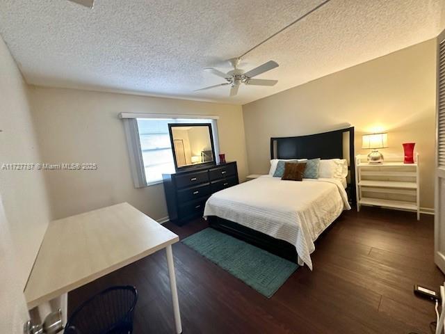 bedroom featuring a textured ceiling, ceiling fan, and dark hardwood / wood-style flooring