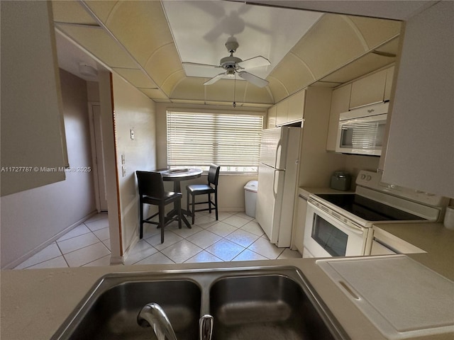 kitchen featuring white appliances, light tile patterned floors, a ceiling fan, and a sink