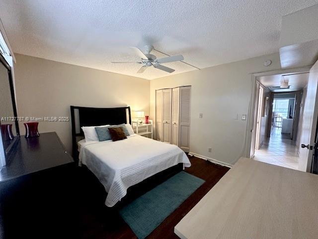 bedroom with ceiling fan, a textured ceiling, a closet, and hardwood / wood-style floors