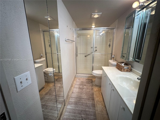 bathroom featuring vanity, toilet, tile patterned floors, and a shower with shower door