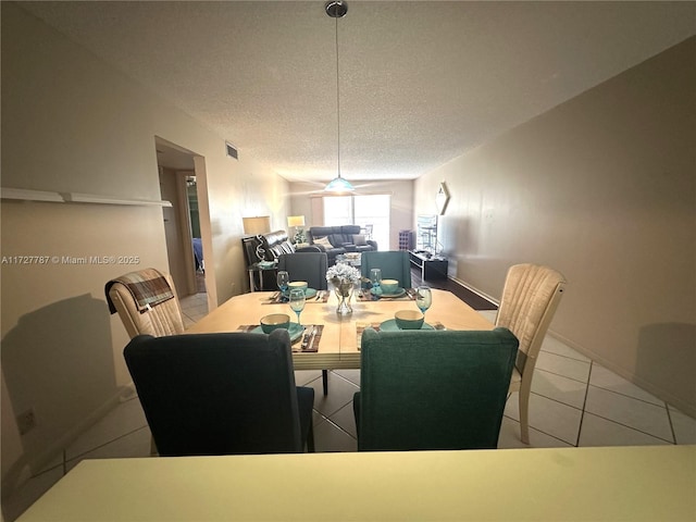 tiled dining area featuring a textured ceiling