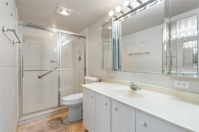 bathroom with toilet, a shower stall, vanity, and tile patterned floors