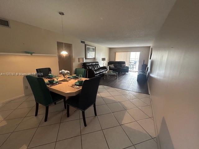 dining space featuring light tile patterned floors and visible vents