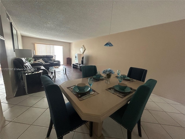 dining area featuring a textured ceiling and light tile patterned flooring