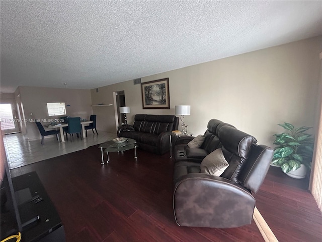 living area with a textured ceiling, wood finished floors, and visible vents