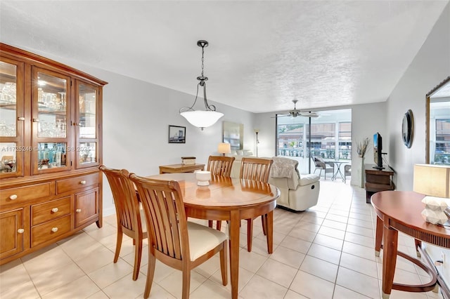 dining area with ceiling fan, light tile patterned floors, and a textured ceiling