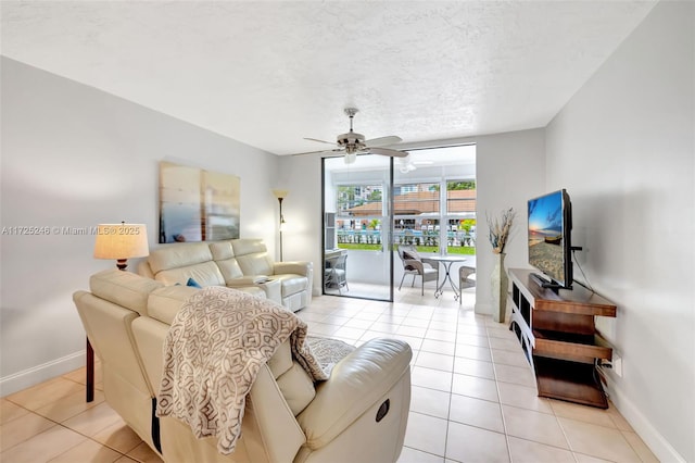 living room with a textured ceiling, ceiling fan, and light tile patterned flooring