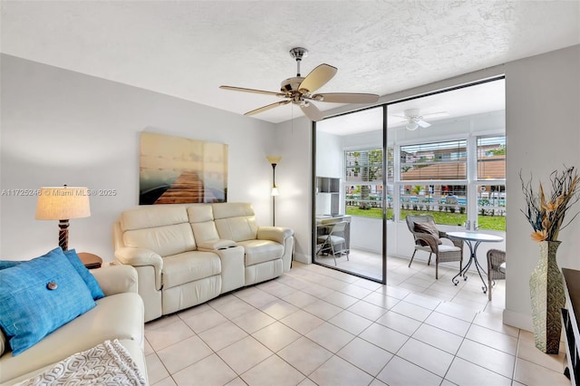 tiled living room with ceiling fan and a textured ceiling