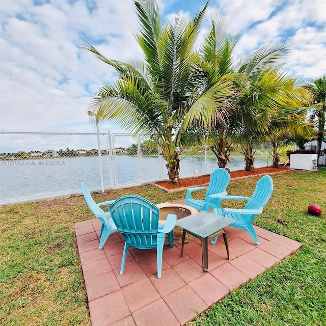 view of patio with a water view and fence