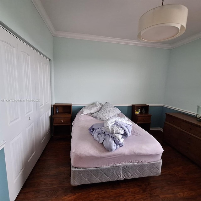 bedroom with crown molding, wood finished floors, and a closet