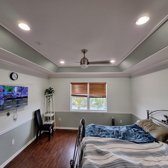 bedroom featuring baseboards, recessed lighting, dark wood-type flooring, crown molding, and a raised ceiling