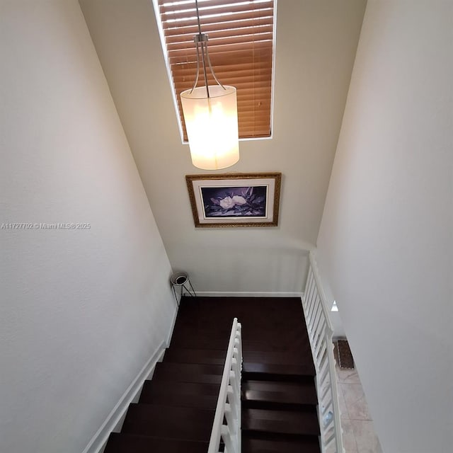 stairway with baseboards and wood finished floors