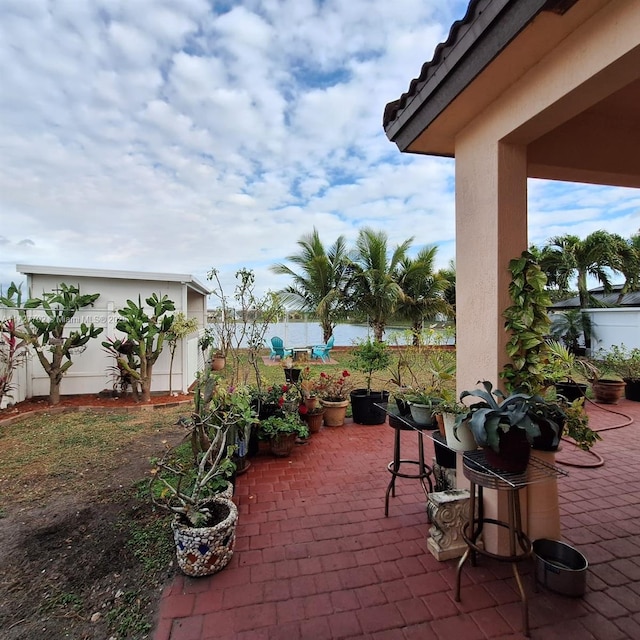 view of patio / terrace with an outdoor structure and fence