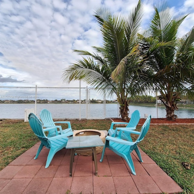 view of patio / terrace with a water view and fence