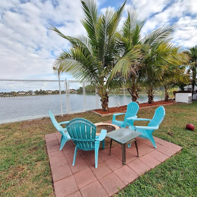 view of patio featuring a water view and fence