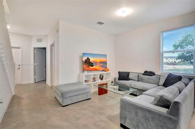 living room featuring light tile patterned floors and a textured ceiling