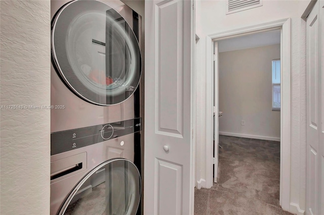 laundry area with light carpet and stacked washer / dryer