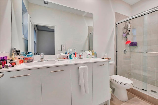 bathroom with a shower with shower door, tile patterned floors, vanity, and toilet