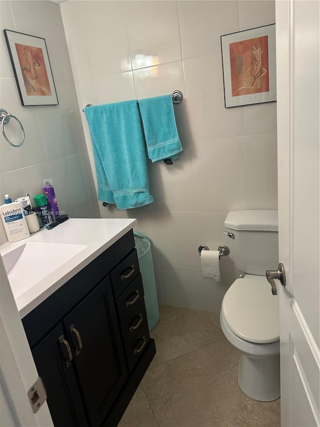 bathroom with tile walls, vanity, and toilet