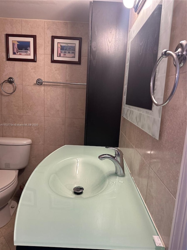 bathroom with tile walls, sink, tile patterned floors, and toilet