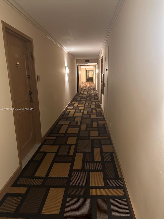 hallway featuring crown molding and dark colored carpet