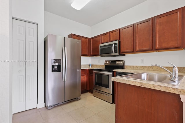 kitchen with light tile patterned floors, sink, and stainless steel appliances