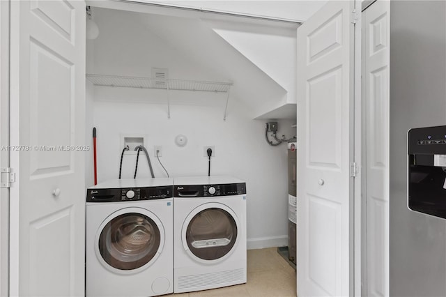 clothes washing area featuring washing machine and clothes dryer and electric water heater