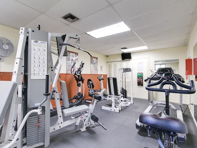 gym with a paneled ceiling