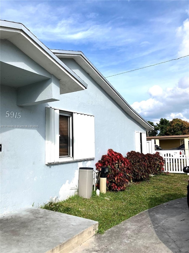 view of side of home with a yard and a patio